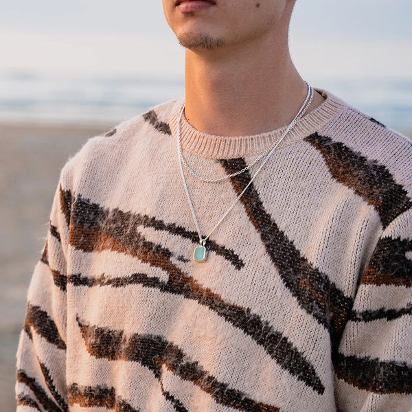 Homme portant un ensemble en argent 925 et pendentif malachite sur la plage